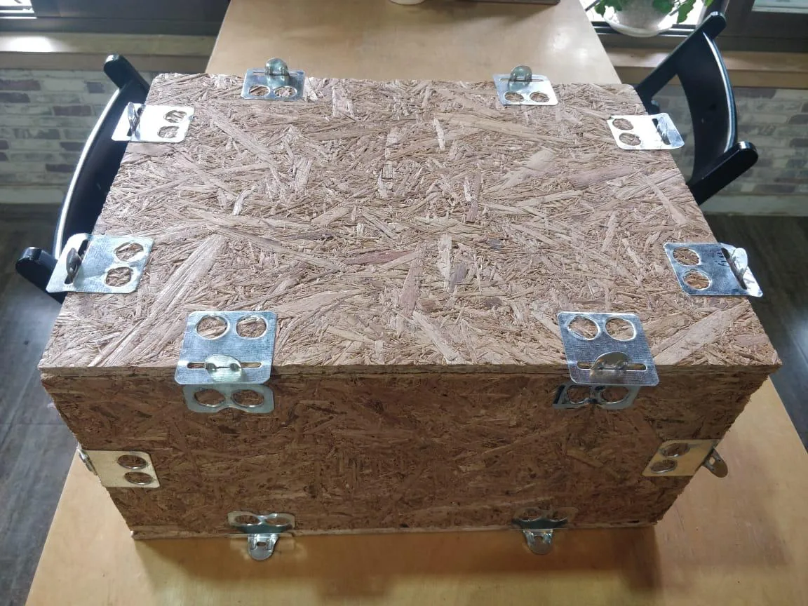 Steel corner fittings and handles bolted to the strand board face of a case